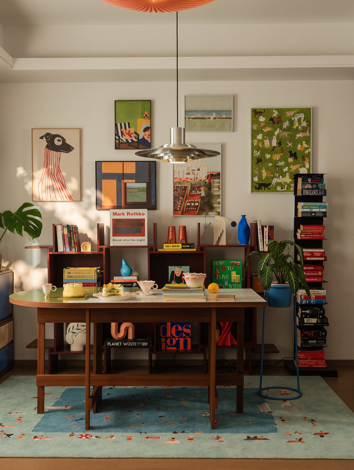 Room interior with a wooden table, books, and decorative items on a light blue rug.