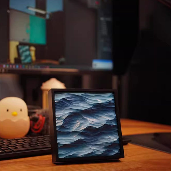 Table displaying a 3D blue wave pattern art on a desk with a blurred background