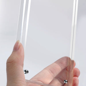 Hand holding a clear acrylic picture frame with a white background