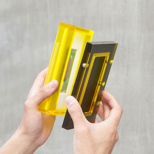 A demonstration of how the acrylic table top frame and the backboard come apart against a gray background