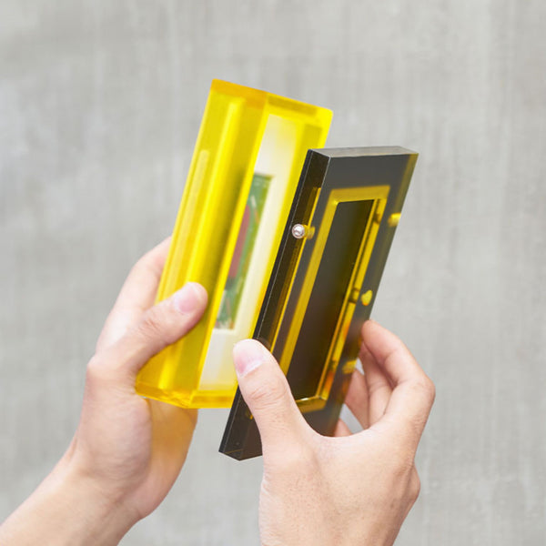 A demonstration of how the acrylic table top frame and the backboard come apart against a gray background