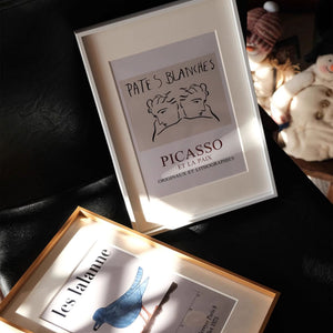 Black aluminum frame artworks on a dark surface with soft lighting