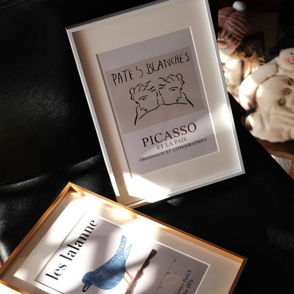 Black aluminum frame artworks on a dark surface with soft lighting