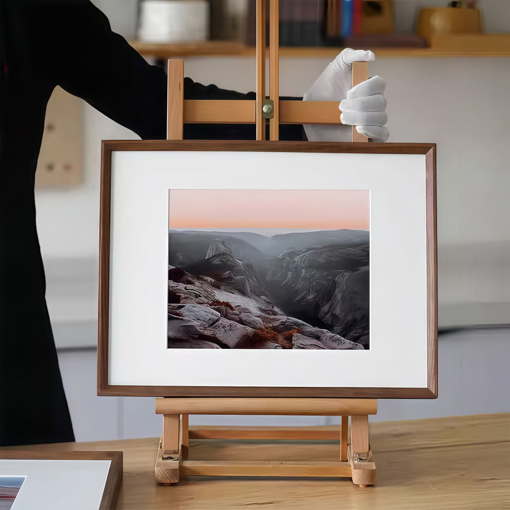 Framed landscape photo on a wooden easel with a blurred background. Made with a black walnut beveled picture frame. 