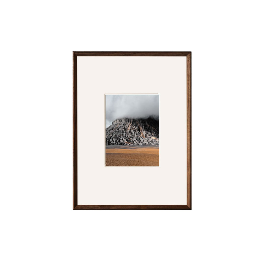 Framed photograph of a mountain landscape on a white background. Black walnut beveled picture frame with mat.