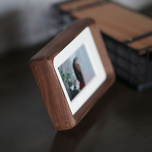 Black walnut wooden photo frame displaying a photo on a dark surface