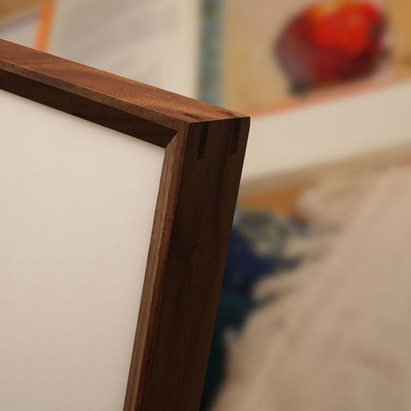 Close-up of a black walnut wooden picture frame corner with a blurred background