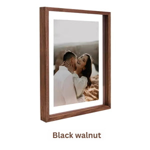 Black walnut wood picture frame with a couple embracing in a field, labeled 'Black walnut'. White background.