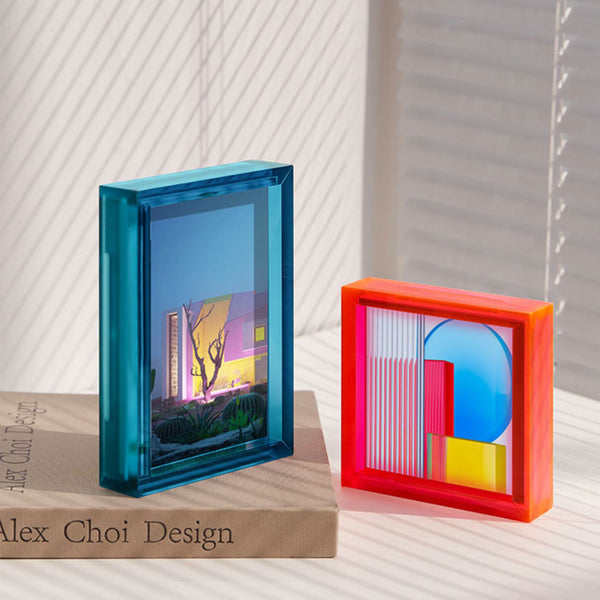 Two colorful acrylic picture frames with geometric designs on a neutral background, featuring 'Alex Choi Design'.