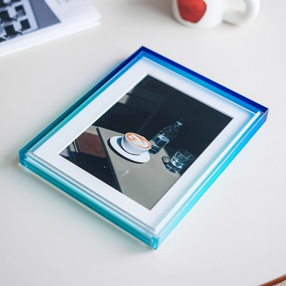 Ombre colour blue and green photo frame with a display showing a hand holding a coffee cup on a white background