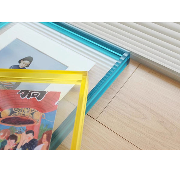Colorful acrylic photo frames on a wooden floor. Blue and Yellow. 