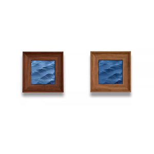 Two square framed artworks with blue wave patterns on a white background