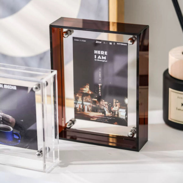 Clear acrylic photo frame with a brown frame on a white surface.