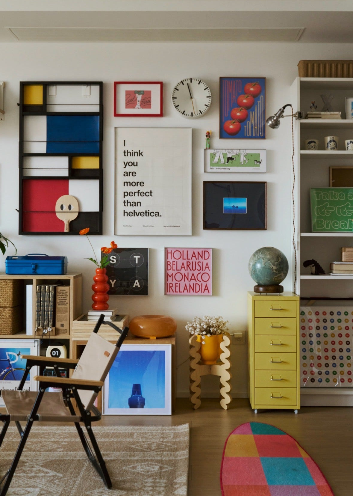 Colorful living room with decorative wall art, furniture, and a rug.