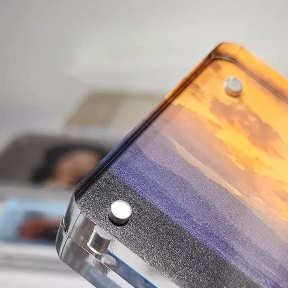 Close-up of a magnetic acrylic picture frame with a scenic design on a blurred background