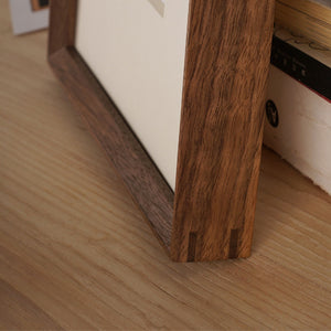 Close-up of a wooden picture frame on a tabletop. Black walnut picture frame.