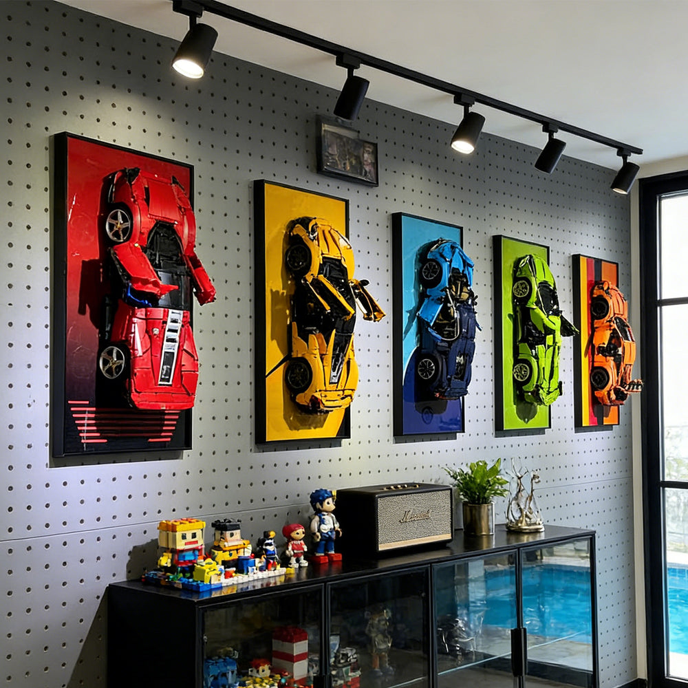 Wall with ONE MAAY framed colorful LEGO Supercar models and a display cabinet below.