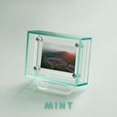 Clear light green picture frame with a scenic image on a light gray background, featuring the brand 'Mint'.