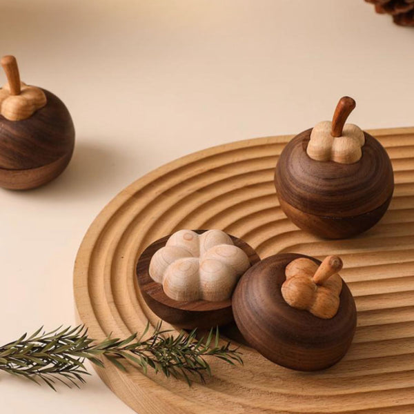 Wooden mangosteen shaped diffuser on a wooden tray with a beige background