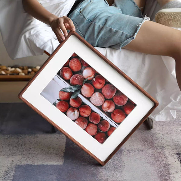 Merbau wood framed artwork of peaches on a small table with a person sitting nearby.