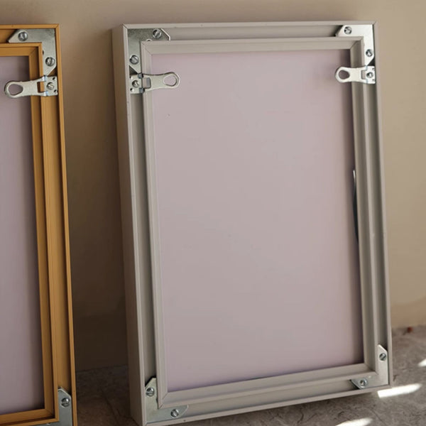 Showing the back of two metal aluminum alloy picture frames, on a neutral background
