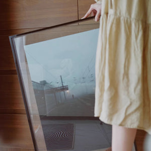 Person holding a red acrylic picture frame 