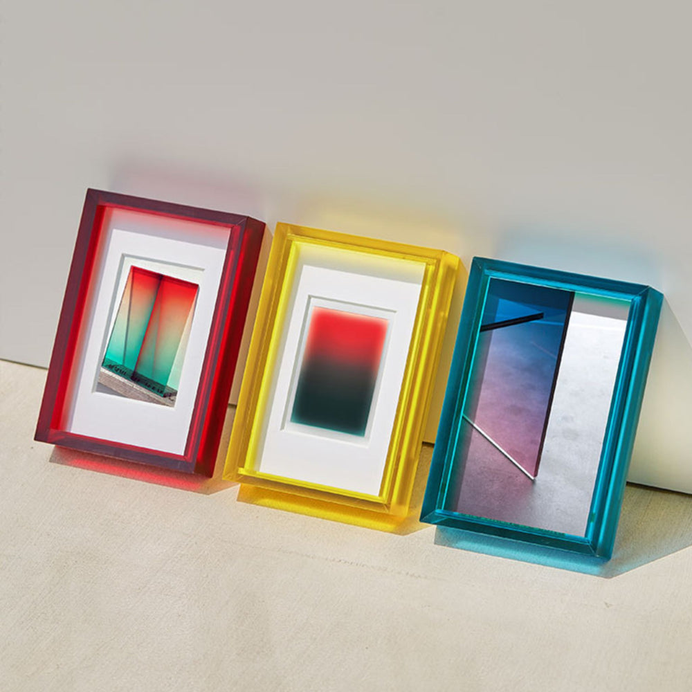 Three colorful picture frames with gradient designs on a light surface.