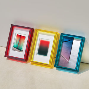 Three colorful picture frames with gradient designs on a light surface.