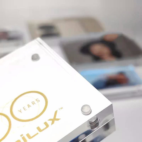 Small rectangular magnetic picture frame on a blurred background of people and photos.