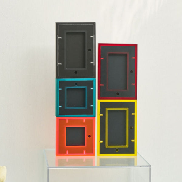 Stack of colorful picture frames on a clear surface with a white background