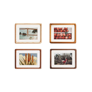 Set of four wooden picture frames with different images on a white background