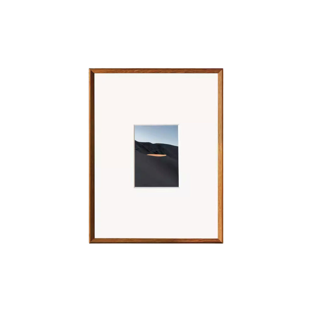 Framed artwork with a landscape scene on a white background. Teak beveled picture frame. 