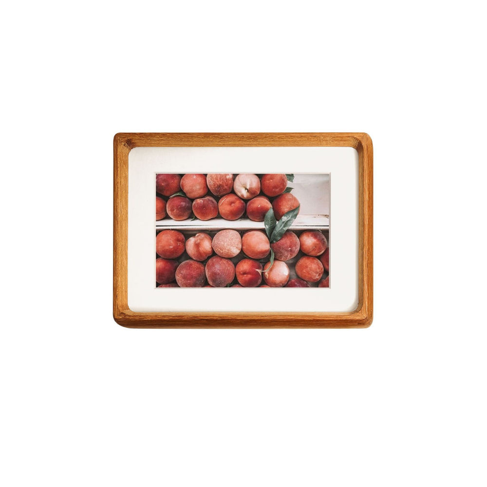 Framed teak picture of peaches on a white background