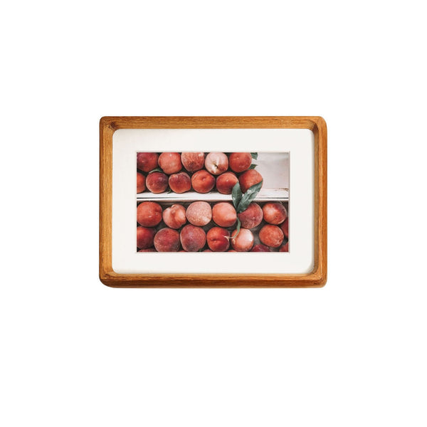 Framed teak picture of peaches on a white background