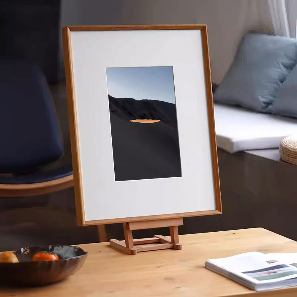 Framed artwork with a landscape scene on a white background. Teak beveled picture frame. 