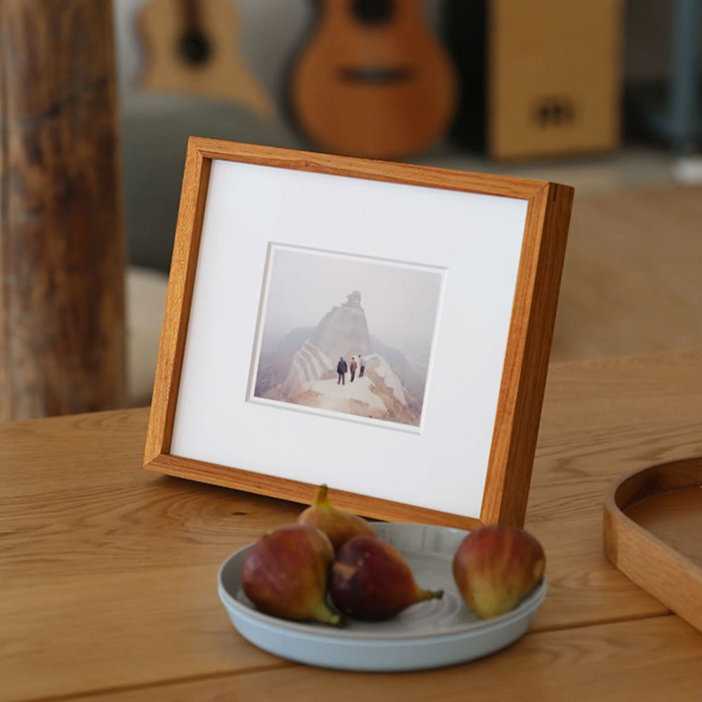 Teak wood framed photograph of two people walking on a mountain with a wooden frame.