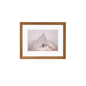 Teak wood framed photograph of two people walking on a mountain with a wooden frame.