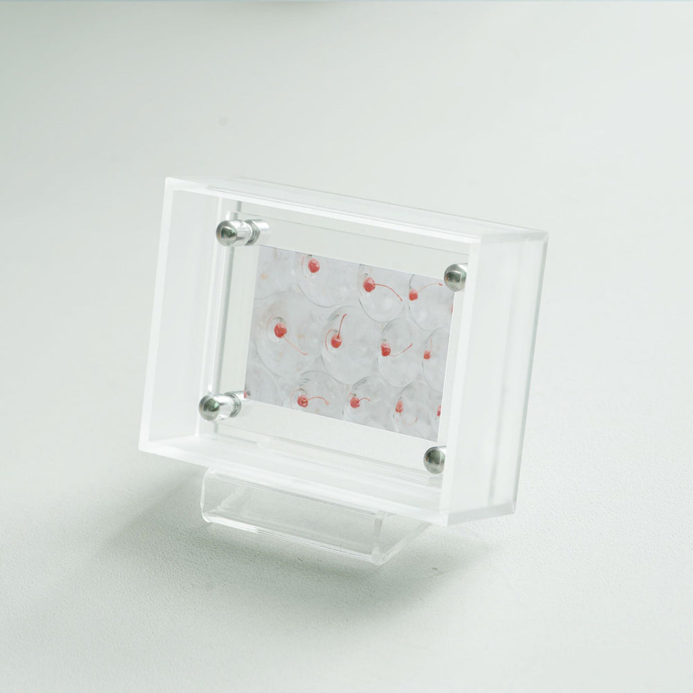 Clear acrylic display frame with a small card on a white background