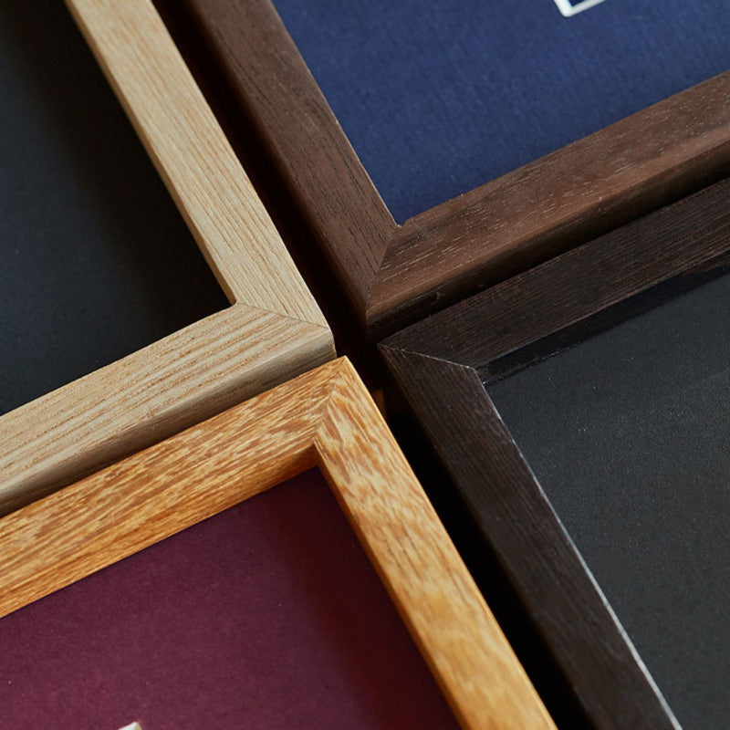 Close-up of wooden picture frames in various colors. Black Walnut, Wenge, White ashwood, Teak wood.