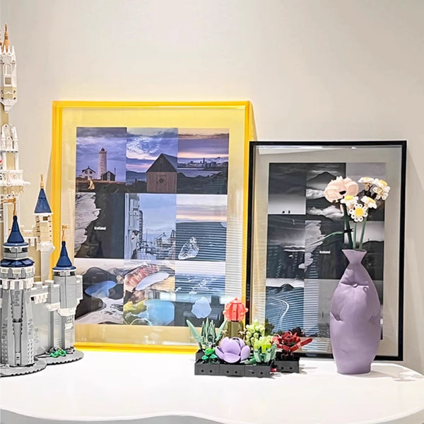 Yellow and black acrylic picture framed artwork on a wall with decorative items including a vase and model buildings.