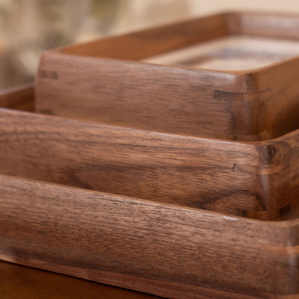Wooden photo frames stacked together with a plant in the background