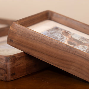 Black walnut picture frame on a wooden surface with a blurred background