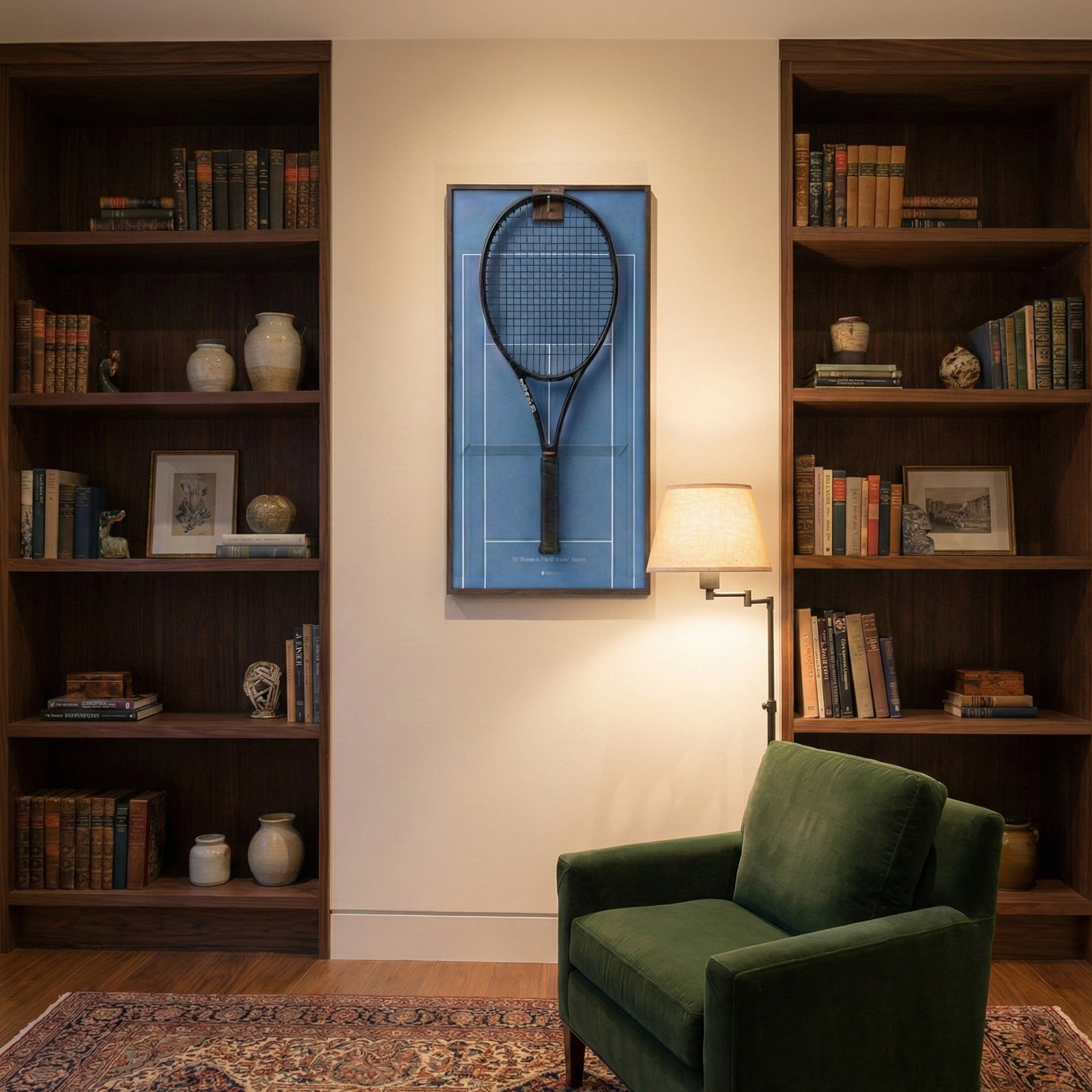 Elegant home library interior showcasing the ONE MAAY Australian Open hard court tennis racket display mounted on the wall next to a built-in wooden bookshelf and a brown leather reading chair.