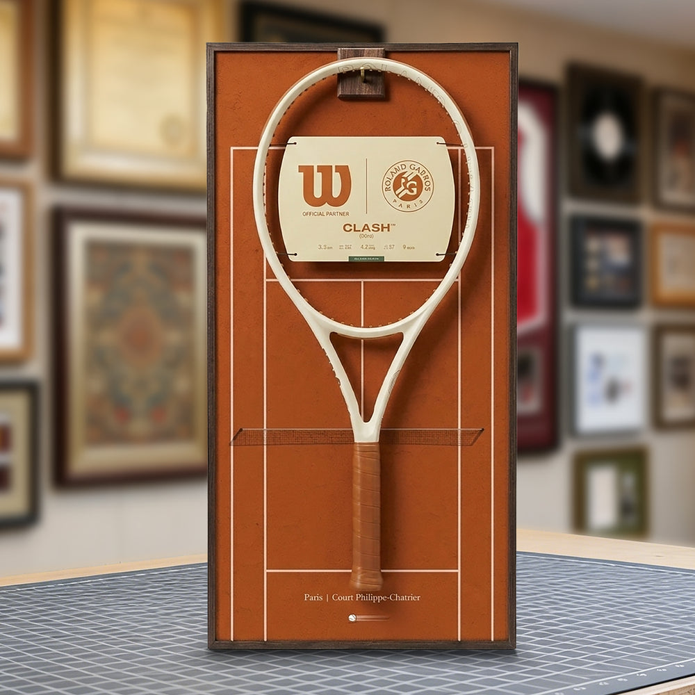 A ONE MAAY French Open-inspired red clay court tennis racket wall display mounted elegantly next to a wooden bookshelf in a home library, featuring a brown side banner that reads "French Open"