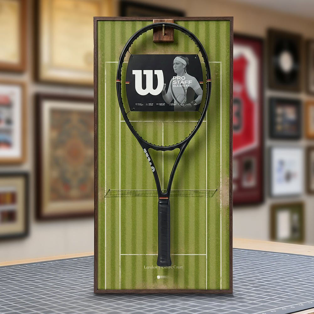 A ONE MAAY Wimbledon-inspired grass court tennis racket wall display mounted elegantly next to a wooden bookshelf in a home library, featuring a green side banner that reads "Wimbledon"