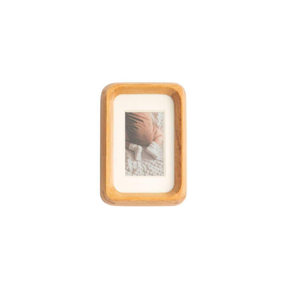 Wooden teak photo frame with a small picture inside on a white mat - mini palm size