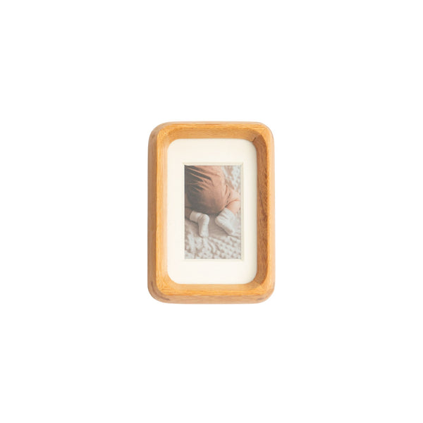 Wooden teak photo frame with a small picture inside on a white mat - mini palm size