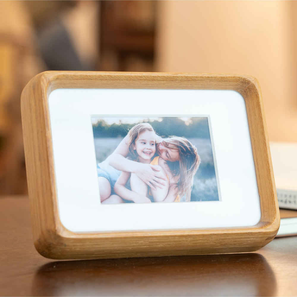 Wooden mini teak photo frame displaying a picture on a wooden surface. 3.5in x 5in. 