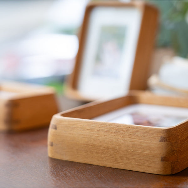 Teak wood picture frame on a wooden surface with a blurred background