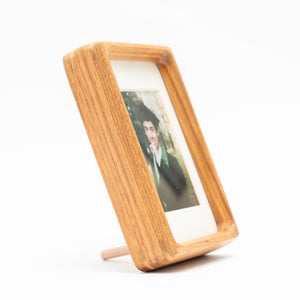 Wooden photo frame with a graduation picture inside on a white background